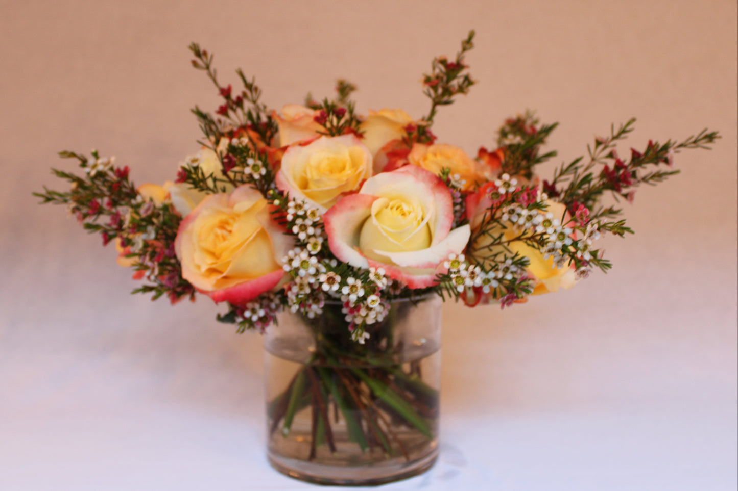 Beautiful spiral round flower arrangement with cabaret roses and pink and white wax flower