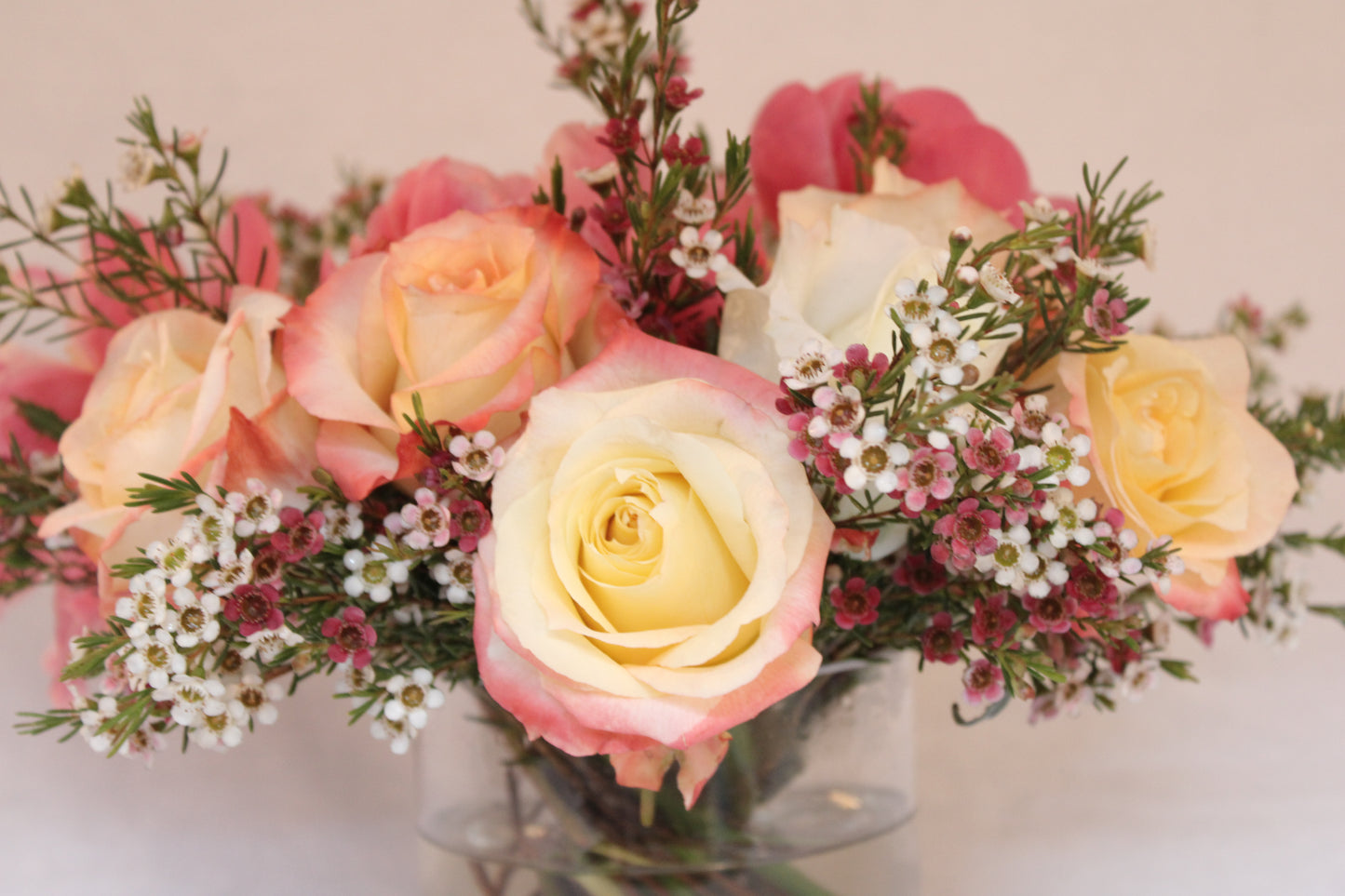 Beautiful spiral round flower arrangement with cabaret roses and coral peonies