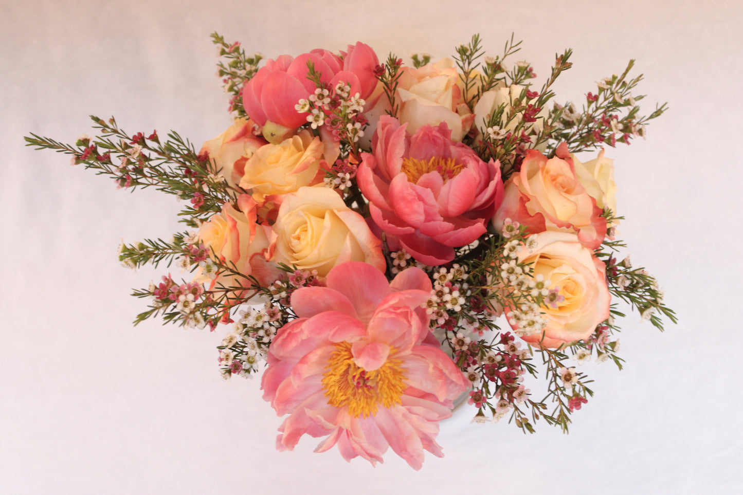 Beautiful spiral round flower arrangement with cabaret roses and coral peonies