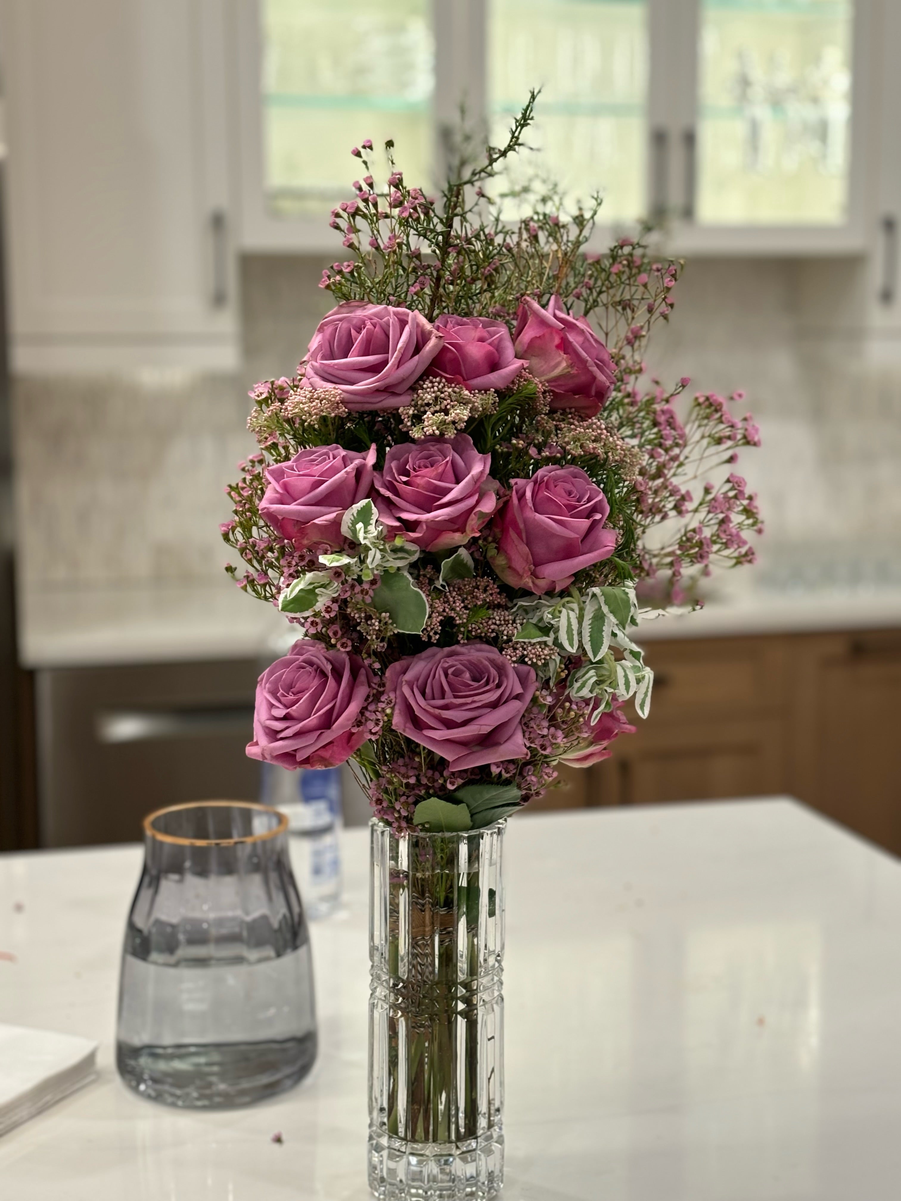 layered proposal bouquet with lavender roses, purple/pink waxflower, and variegated greenery