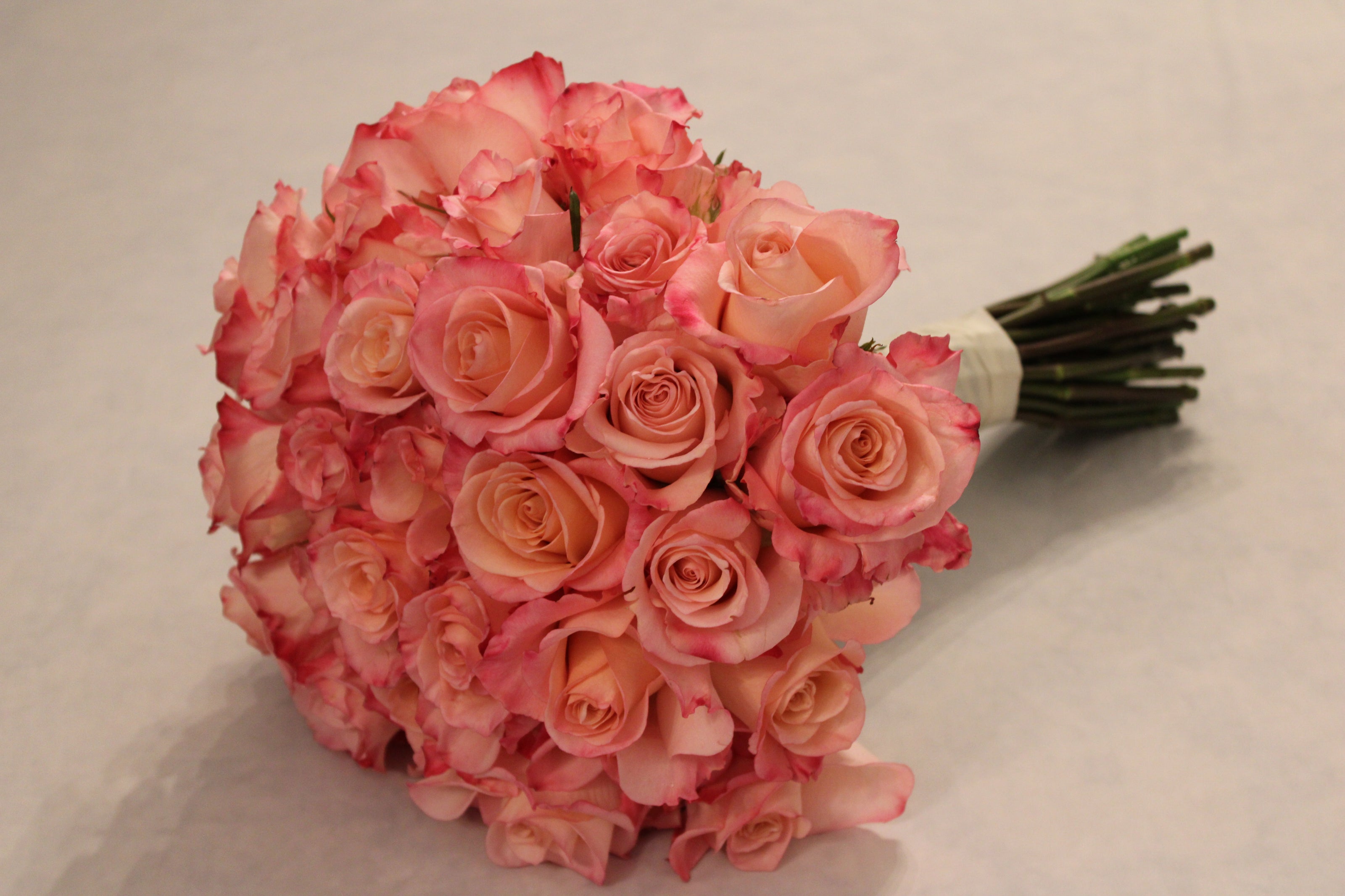 Proposal bouquet of pink Rhoslyn roses with coral and hot pink tones. Round, modern-style bouquet.