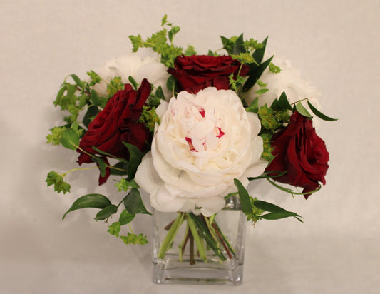 small floral arrangement in 3x4x6 glass rectangular vase with peonies, roses, and bupleurum 