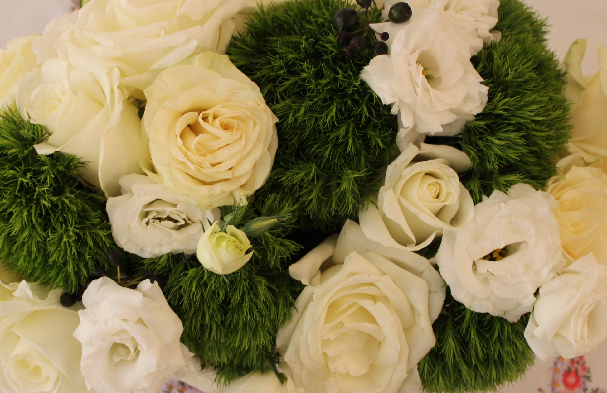 Tibet roses, Playa Blanca roses, green trick carnations, white lisianthus, huckleberry.