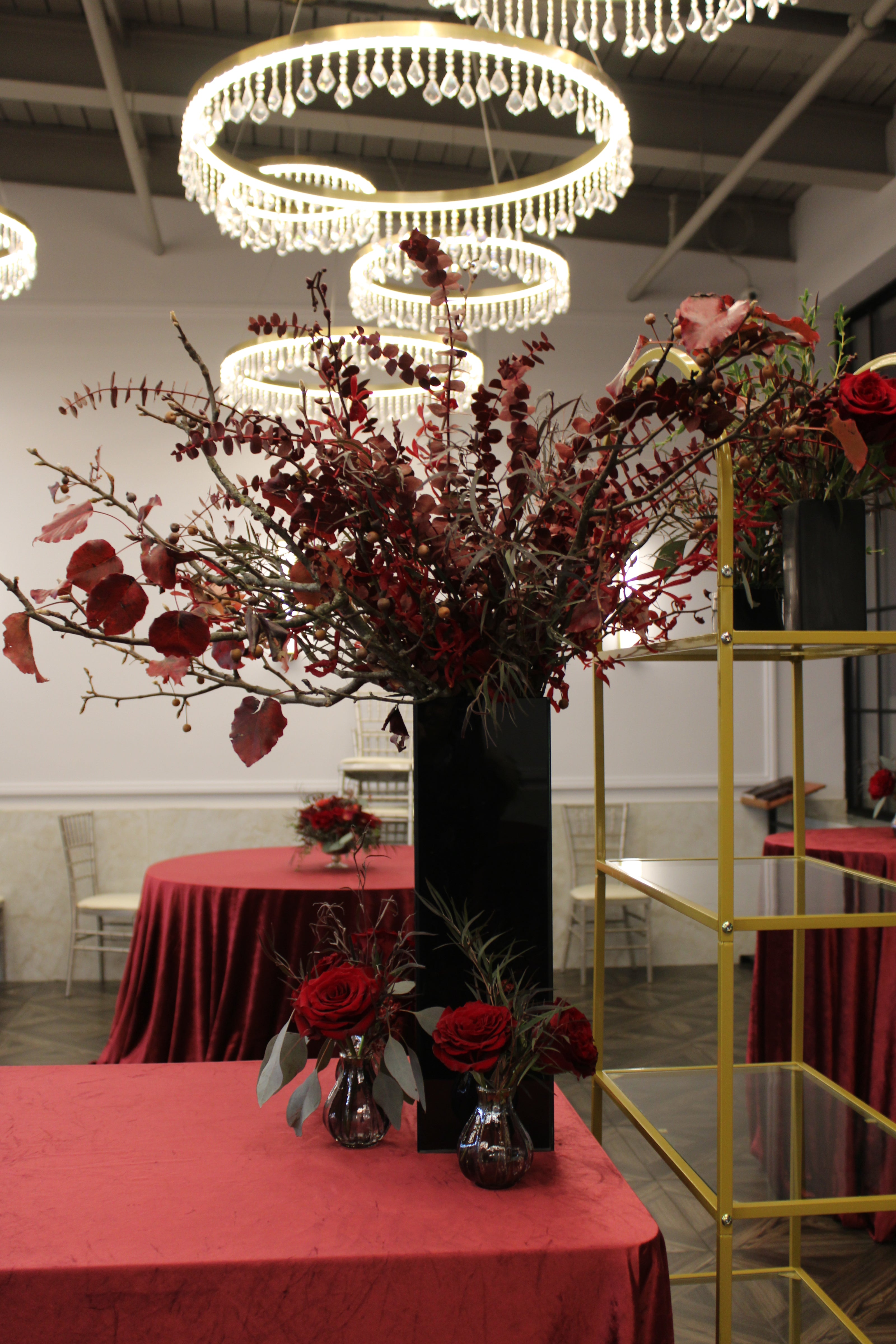 Modern tall black glass vase with burgundy florals and foliage