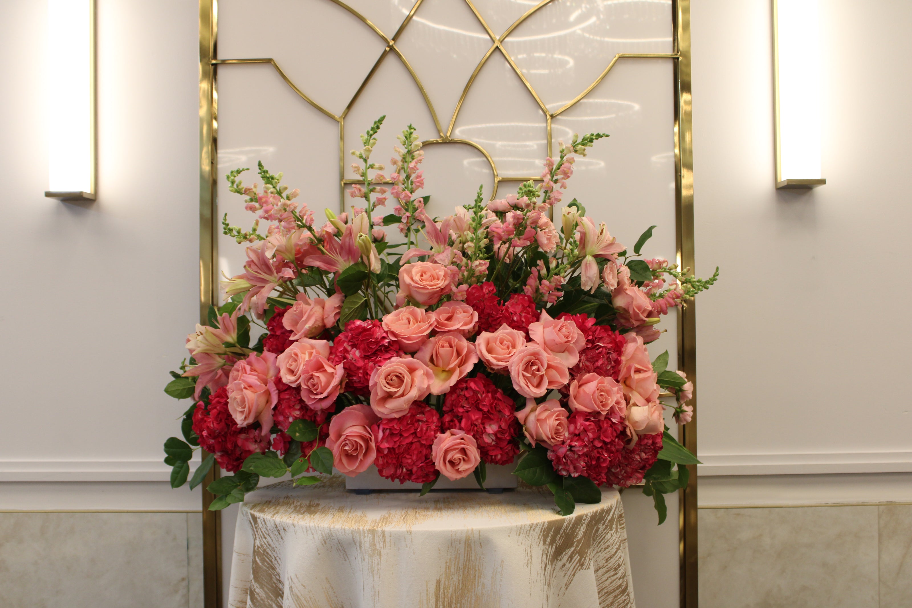 Different shades of pink flowers in white planter for vort chosson centerpiece